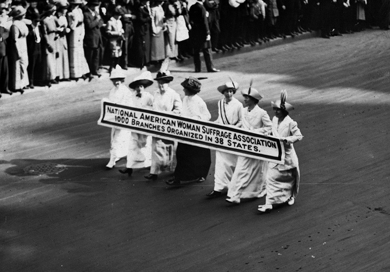 Members of the National American Woman Suffrage Association marching with a banner at the New York Suffragette Parade on May 3, 1913 – Paul Thompson, Getty Images